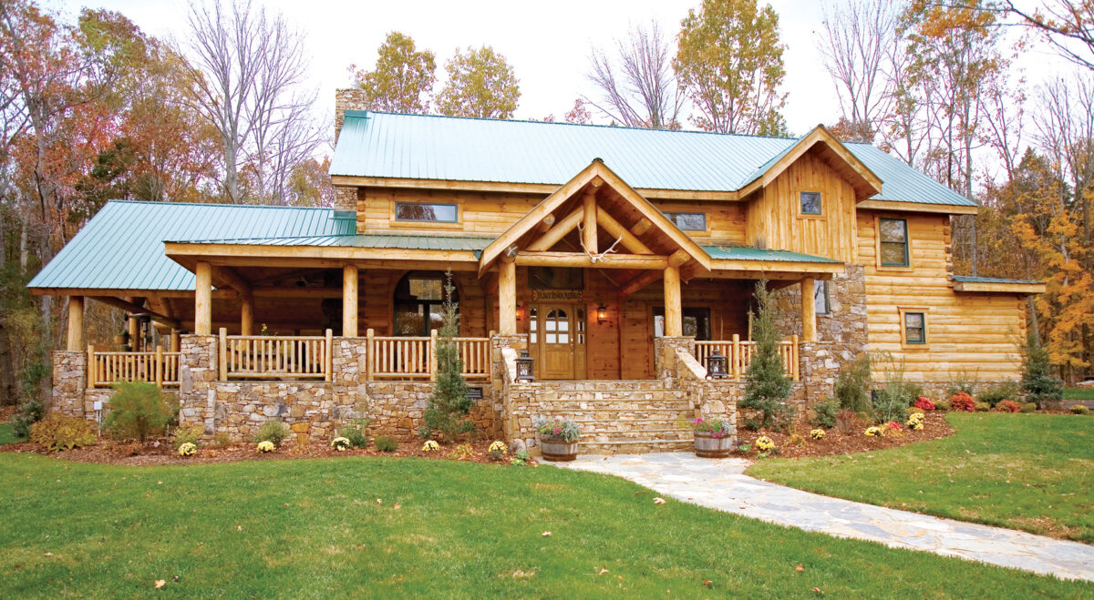 Gorgeous log home with stone accents and green metal roof.